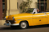 A+convertible+car+parked+in+front+of+a+building%2C+Havana%2C+Cuba