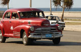 Antique+cars+moving+on+a+road%2C+Havana%2C+Cuba
