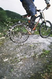 Man+outdoors+on+trails+jumping+bicycle+over+puddles+%28selective+focus%29