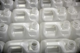 Bottles+in+factory+rows%2C+white+plastic+environment+recycle+metaphor
