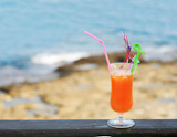 one+orange+cocktail+against+sea+and+coastline