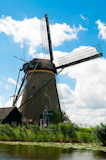 Dutch+windmill+in+a+town+called+Kinderdijk+against+a+blue+sky+with+clouds.