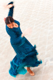 A+motion+blurred+slow+shutter+speed+shot+of+a+woman+traditional+Spanish+Flamenco+dancer+spinning+and+dancing+in+a+blue+polka+dot+dress