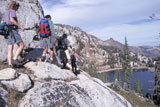 Hikers+Traversing+A+Rocky+Ridge+Overlooking+A+Lake