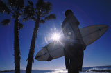 Silhouette+of+a+man+holding+a+surfboard+standing+on+a+beach