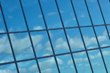 Reflection+of+blue+sky+in+glass+windows+of+building