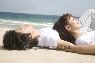ビーチで寝転がるカップル 商用利用可能な写真素材 イラスト素材ならストックフォトの定額制ペイレスイメージズ