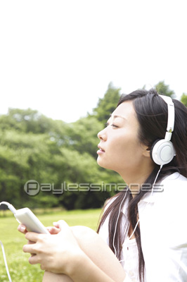 公園で音楽を聞く女性