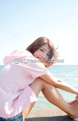 海辺で座る女性