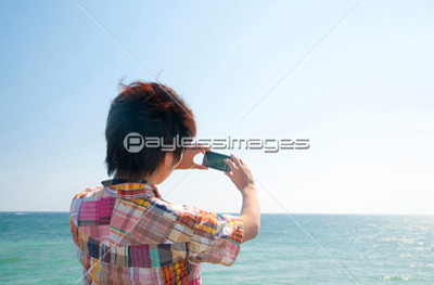 携帯電話で写真を撮る男性