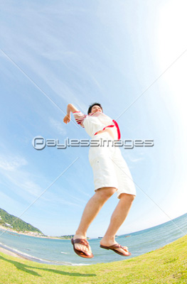 海辺でジャンプする男性