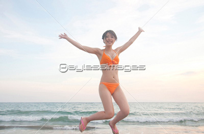 海でジャンプする水着女性
