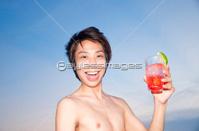 海辺でカクテルを飲む男性