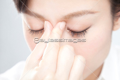 目頭を押さえる女性 ストックフォトの定額制ペイレスイメージズ