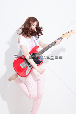 ギターを演奏する女性 商用利用可能な写真素材 イラスト素材ならストックフォトの定額制ペイレスイメージズ