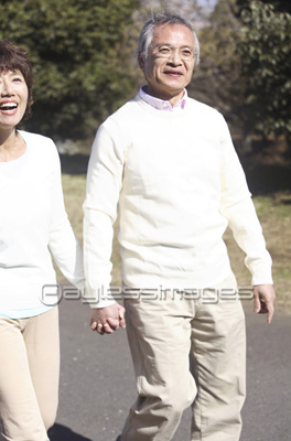 手をつないで公園を歩くシニアカップル ストックフォトの定額制ペイレスイメージズ