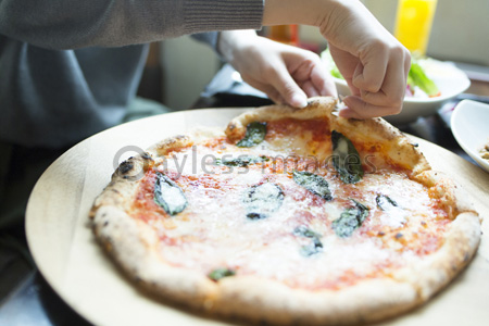 ピザを食べる女性の手元の写真 イラスト素材 Af9900116512