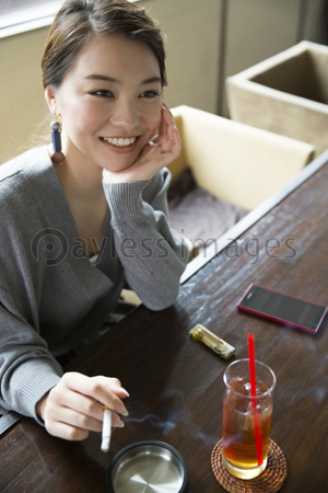 飲食店で喫煙する女性 商用利用可能な写真素材 イラスト素材ならストックフォトの定額制ペイレスイメージズ