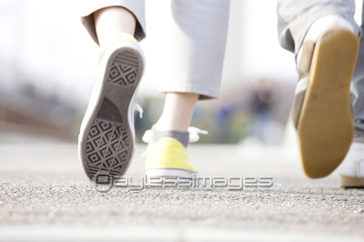 スニーカーで歩く男女の足元 商用利用可能な写真素材 イラスト素材ならストックフォトの定額制ペイレスイメージズ
