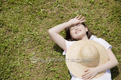 芝生に寝転がる女性 - 商用利用可能な写真素材・イラスト素材ならストックフォトの定額制ペイレスイメージズ