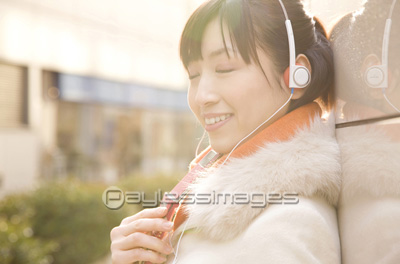 ヘッドフォンで音楽を聴いている女性