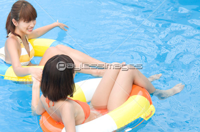 浮輪を持ってプールで遊ぶ水着女性2人 商用利用可能な写真素材 イラスト素材ならストックフォトの定額制ペイレスイメージズ