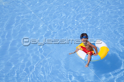 浮き輪でプールに浮かぶ水着姿の男の子 商用利用可能な写真素材 イラスト素材ならストックフォトの定額制ペイレスイメージズ