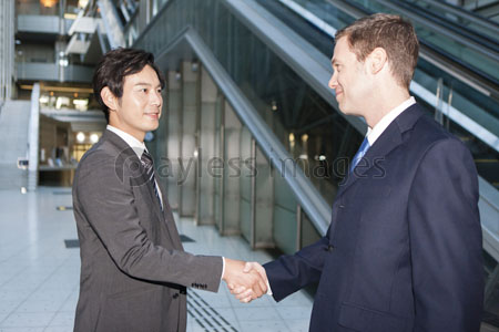 握手をする日本人ビジネスマンと外国人ビジネスマン ストックフォトの定額制ペイレスイメージズ