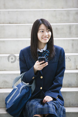 スマートフォンをいじる女子高生 商用利用可能な写真素材 イラスト素材ならストックフォトの定額制ペイレスイメージズ