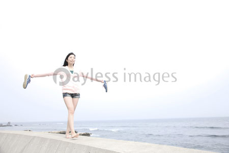 防波堤の上を歩く女性 商用利用可能な写真素材 イラスト素材ならストックフォトの定額制ペイレスイメージズ