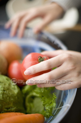 野菜を手に取る女性