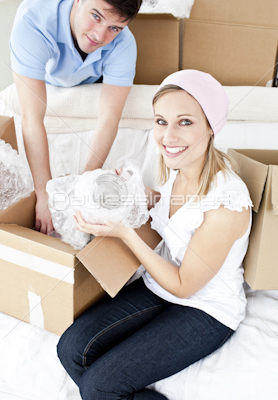 Animated young couple packing a box