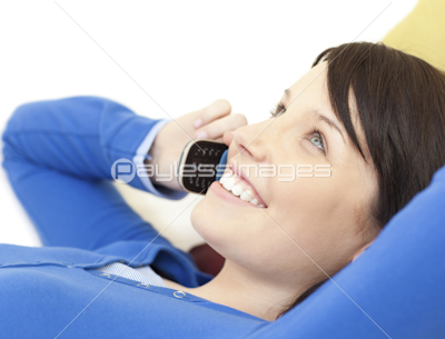 Attractive young woman talking on phone lying on a sofa