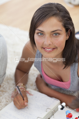 Beautiful teenager studying on the floor