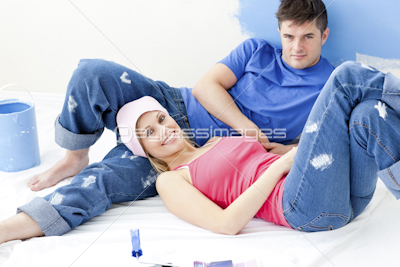 Cute couple relaxing after paiting a room