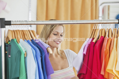 Cute young woman holding a colorful shirt