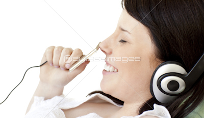 Joyful teen girl listening music lying on a sofa