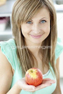 Portrait of a beautiful woman holding an apple looking at the camera