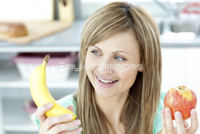 Positive woman holing a bananan and an apple