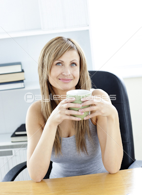 Relaxed woman holding a cup sitting on a chair