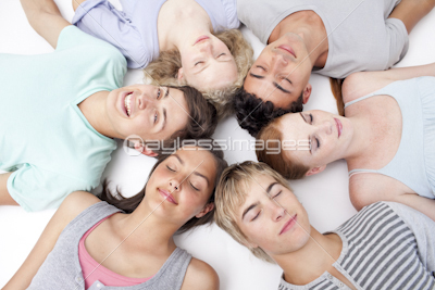 Teens lying on floor with heads together