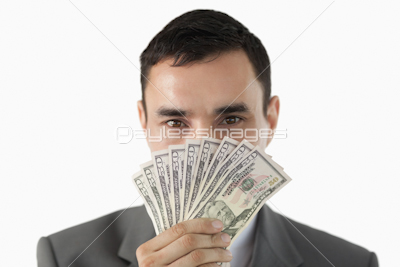 Businessman smelling on banknotes