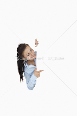 Businesswoman pointing while looking around the corner