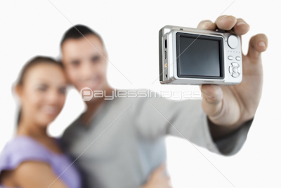 Camera being used to take a picture of young couple