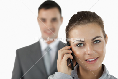Close up of businesswoman on the phone with colleague behind her
