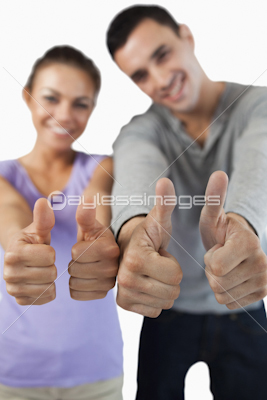 Close up of thumbs up being given by young couple