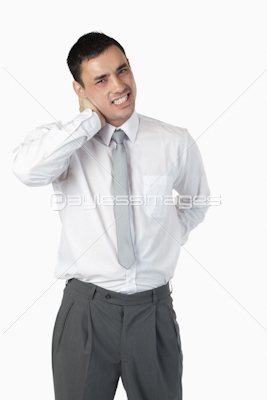 Portrait of a young businessman having a back pain