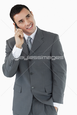 Smiling businessman looking diagonally upwards while on the phone