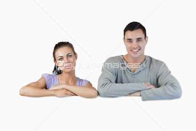 Smiling young couple looking over a wall