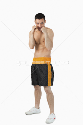 Young boxer with bare fists taking cover